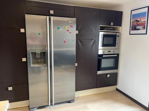 Il comprend une cuisine équipée d'un réfrigérateur en acier inoxydable et d'une cuisinière. dans l'établissement L'Horizon du Beffroi, à Millau