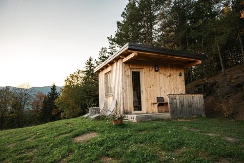 a small wooden cabin on a hill in a field at Glamping Gril in Ljubno