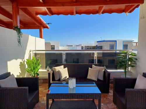 a patio with a couch and a table on a balcony at Mini Villa 2 Al hoceima in Al Hoceïma