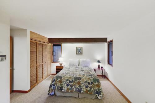a bedroom with a bed and a white wall at The Eagle's Nest in Otis
