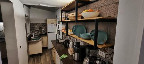 a kitchen with a counter with plates and bowls at "The Sisters' Hostel" the women only hostel in Adeje