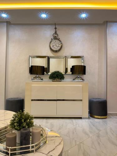 a vanity with two mirrors and a clock on a wall at Mini Villa 2 Al hoceima in Al Hoceïma