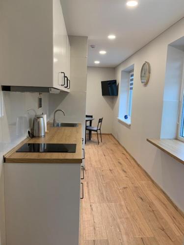 a kitchen with a sink and a wooden floor at Cozy apartment in Karmelava in Karmėlava
