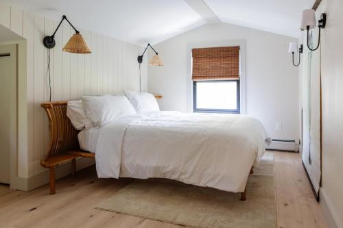 a bedroom with a large white bed and a window at The Bend Micro Resort in Phoenicia
