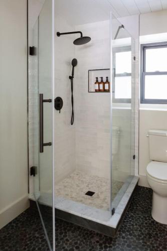 a bathroom with a glass shower with a toilet at The Bend Micro Resort in Phoenicia