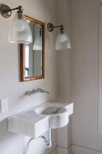 a bathroom with a white sink and a mirror at The Bend Micro Resort in Phoenicia