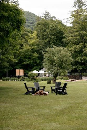 two benches sitting in the grass in a park at The Bend Micro Resort in Phoenicia