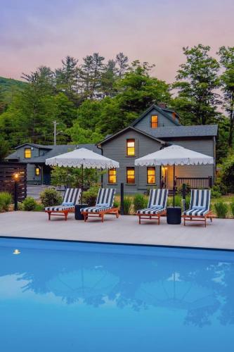 a house with chairs and umbrellas next to a pool at The Bend Micro Resort in Phoenicia