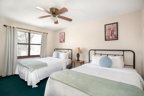 a bedroom with two beds and a ceiling fan at Cozy Smoky Mountain Escape w/ Private Deck & Community Pool in Pigeon Forge