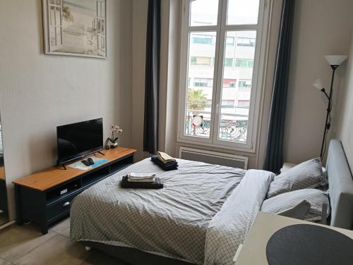 une chambre avec un lit et un bureau avec une télévision dans l'établissement Studio central Nice, à Nice