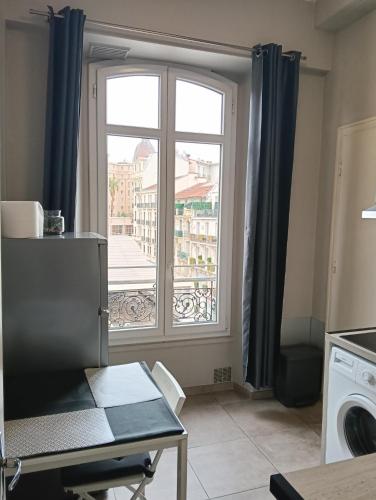 une cuisine avec une fenêtre offrant une vue sur la ville dans l'établissement Studio central Nice, à Nice