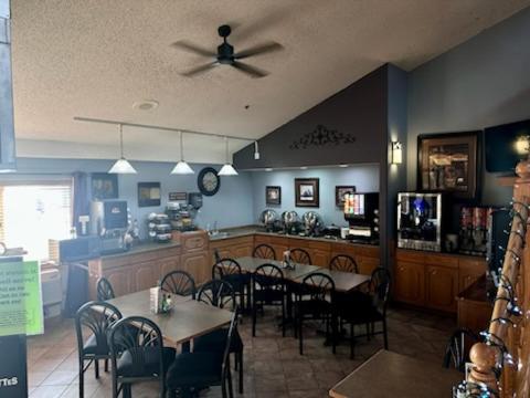 a dining room with tables and chairs in a restaurant at Fossil Creek Hotel & Suites in Russell
