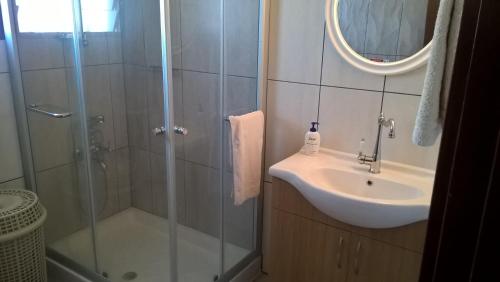 a bathroom with a shower and a sink and a mirror at Patriko Village Home in Pissouri
