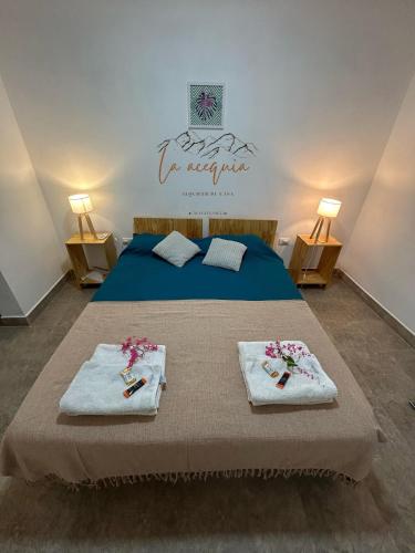 a bedroom with a bed with towels on it at La acequia casa in Cafayate