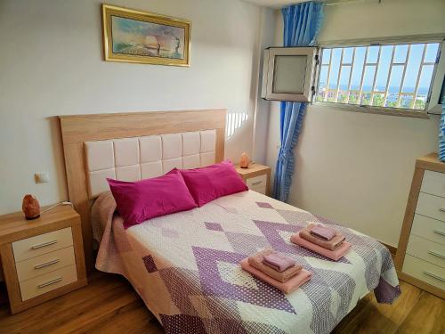 a bedroom with a bed with two towels on it at Residencial Los Molinos con piscina, TV internacional y Wifi in Playa del Ingles