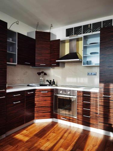 a kitchen with wooden cabinets and a stainless steel oven at The View Appartment in Český Krumlov