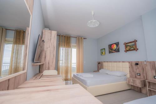 a bedroom with two beds and a tv in it at Klebrido Hotel and Restaurant in Durrës