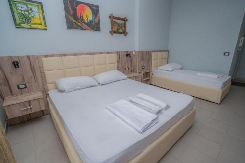 a bedroom with two beds with white towels on them at Klebrido Hotel and Restaurant in Durrës