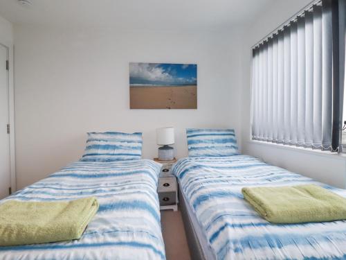 two beds sitting next to each other in a bedroom at Crantock Reach in Newquay