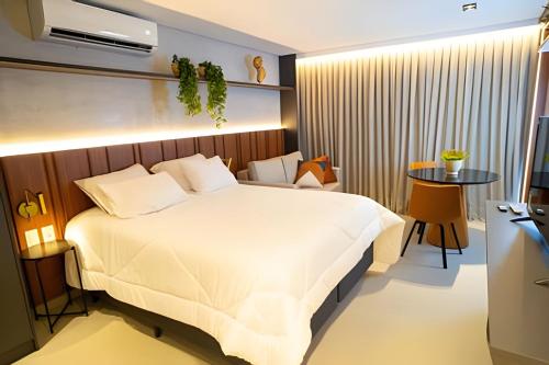 a bedroom with a large bed and a table at Flat novo, moderno e super bem localizado in Tambaú