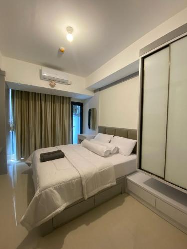 a bedroom with a large bed and a window at Pollux Studio Apartment 1618 Free Wifi & Netflix in Jodoh