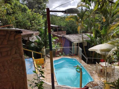 圣路易斯-杜帕赖廷加Pousada e Hostel Cantinho dos Chalés的房屋后院的游泳池