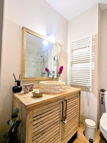 une salle de bain avec un lavabo et un miroir dans l'établissement La bulle Uzétienne, à Uzès