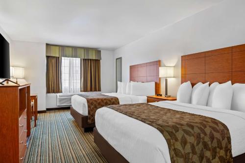 a hotel room with two beds and a television at Best Western Liberty Inn in Delano