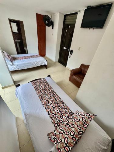 a room with two beds and a flat screen tv at Hotel Tucan Pereira in Pereira