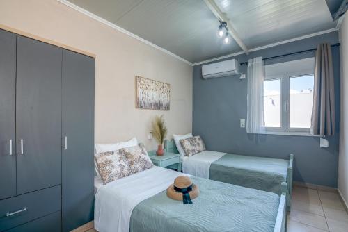 ein Schlafzimmer mit 2 Betten und einem Hut auf einem Bett in der Unterkunft Margie's Apartments in Kissamos