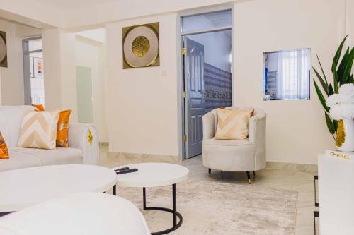 a living room with a couch and a chair and a table at Urban suites 2 bedroom Master ensuite holiday rental nanyuki in Nanyuki