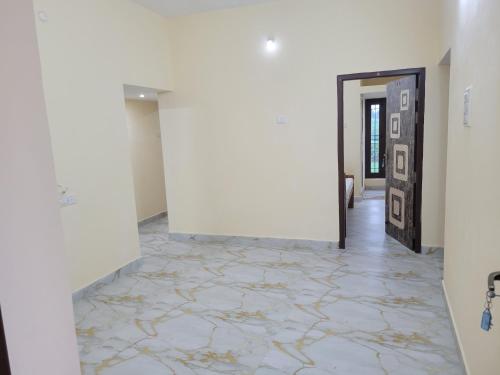 a hallway with a white wall and a tile floor at Medhaa Homes Madurai in Madurai