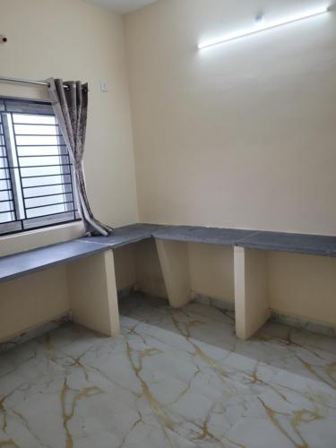 a bench in a room with a window at Medhaa Homes Madurai in Madurai
