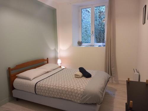 a bedroom with a bed with a teddy bear on it at Balade sur le port in Dinan