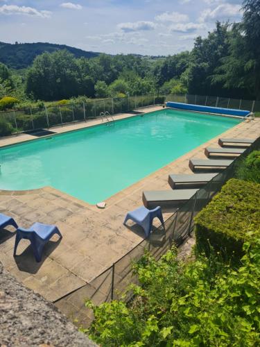una piscina vacía con sillas azules y árboles en Le Domaine du Crescent, en Chezelles