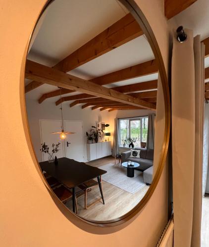a mirror reflecting the living room and dining room at Green Escape Hellendoorn rust & natuur in Hellendoorn