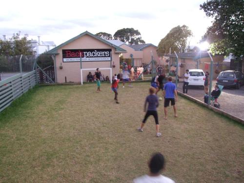 a group of people playing a game of soccer in a field at 1849 Backpackers Albany in Albany