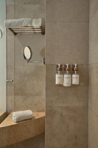 y baño con ducha y 3 botellas de jabón. en Now Hotel Cali, en Cali