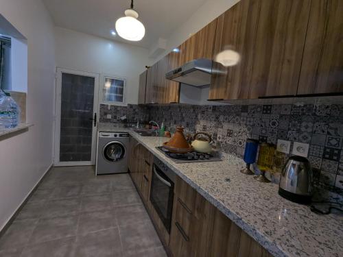 a kitchen with wooden cabinets and a washer and dryer at Dar SAÏDA in Marrakech