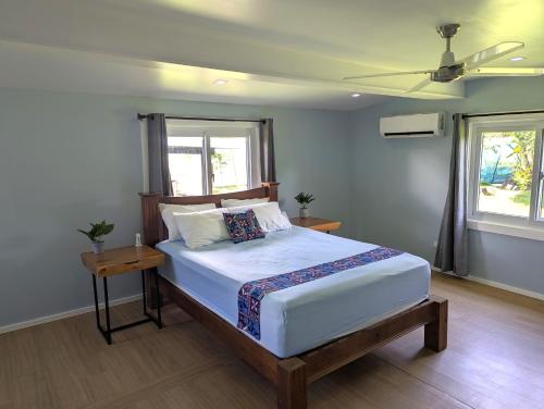 a bedroom with a bed and a ceiling fan at Raintree Gardens - 1 Acre, Ocean Views, Steps from beach in Matei