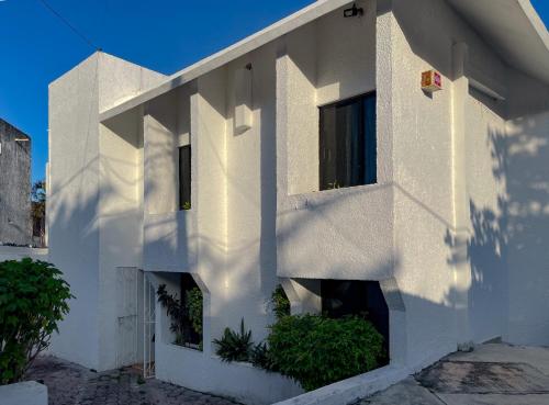 a white building with plants on the side of it at Casa Luna Family & Friends in Cancún