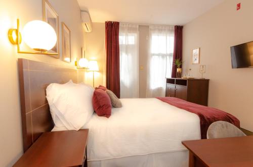 a hotel room with a white bed and a table at Hotel Dorion in Montréal