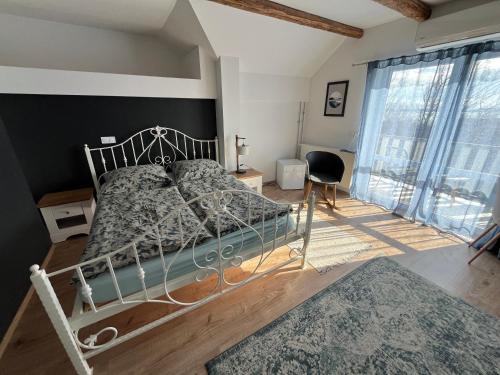 a bedroom with a bed and a large window at Patent, your home in Badacsony in Badacsonytomaj