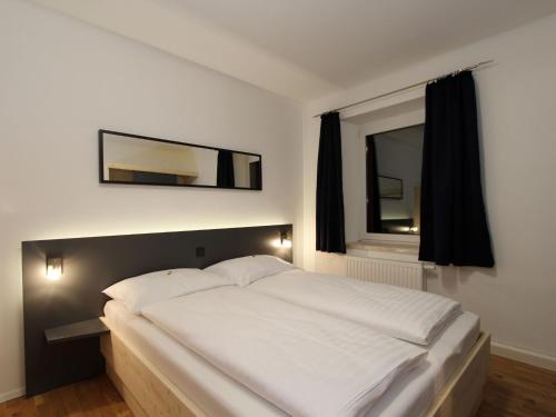 ein Schlafzimmer mit einem großen weißen Bett und einem Spiegel in der Unterkunft Pleasing Apartment in Kaltenbach near Ski Area in Eisenerz