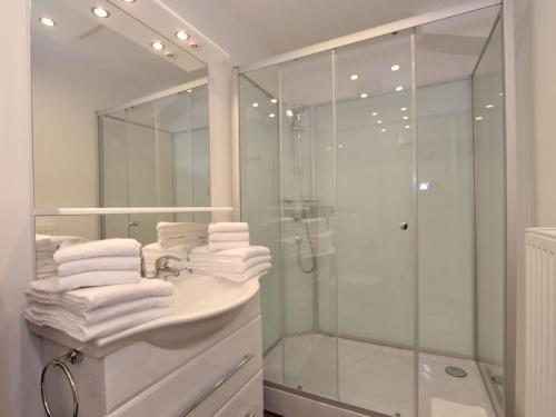 ein Bad mit einer Dusche und einem Waschbecken mit Handtüchern in der Unterkunft Pleasing Apartment in Kaltenbach near Ski Area in Eisenerz
