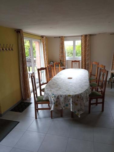 une salle à manger avec une table et des chaises blanches dans l'établissement Maison de vacances centre Alsace, à Grussenheim