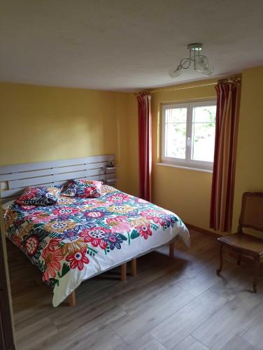 - une chambre avec un lit doté d'un couvre-lit coloré dans l'établissement Maison de vacances centre Alsace, à Grussenheim