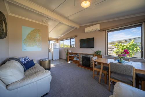 a living room with a white couch and a table at The Crib Haven - Te Anau Holiday Home in Te Anau