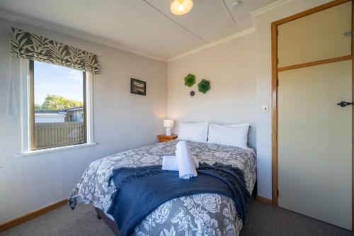 a bedroom with a bed and a window at The Crib Haven - Te Anau Holiday Home in Te Anau
