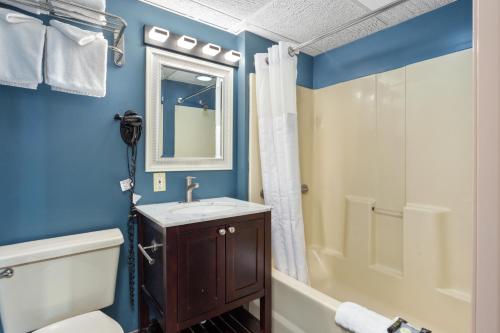 a bathroom with a toilet and a sink and a shower at Americana Motor Inn on Boardwalk in Ocean City